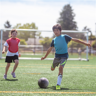 2 children playing soccer