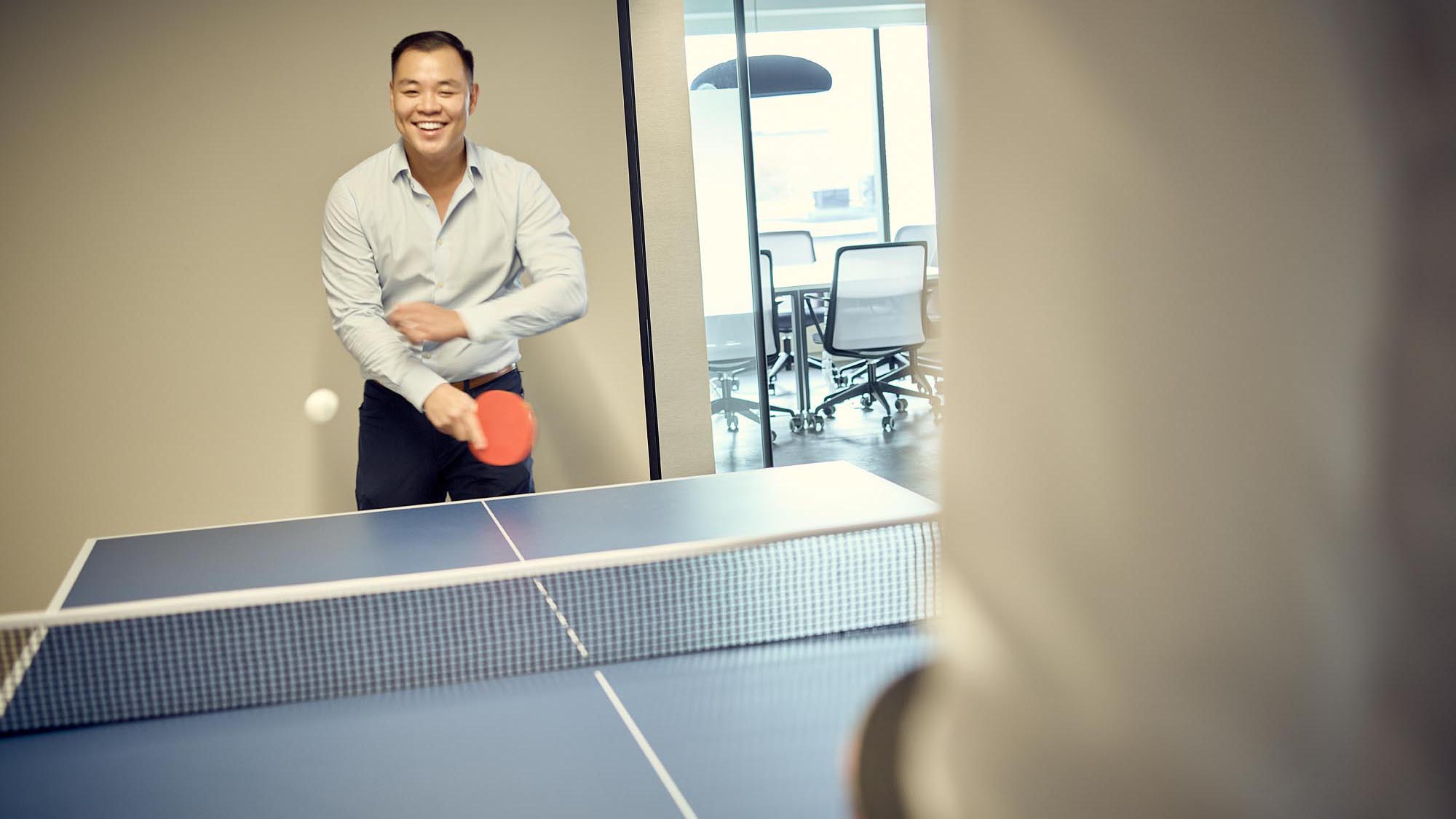 Two employees playing ping pong in an office